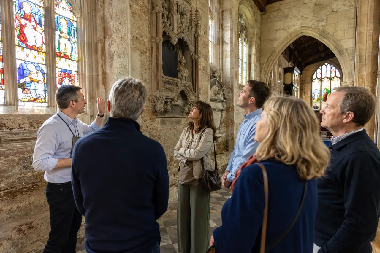 Guide présentant un vitrail de saint Georges dans une église anglaise