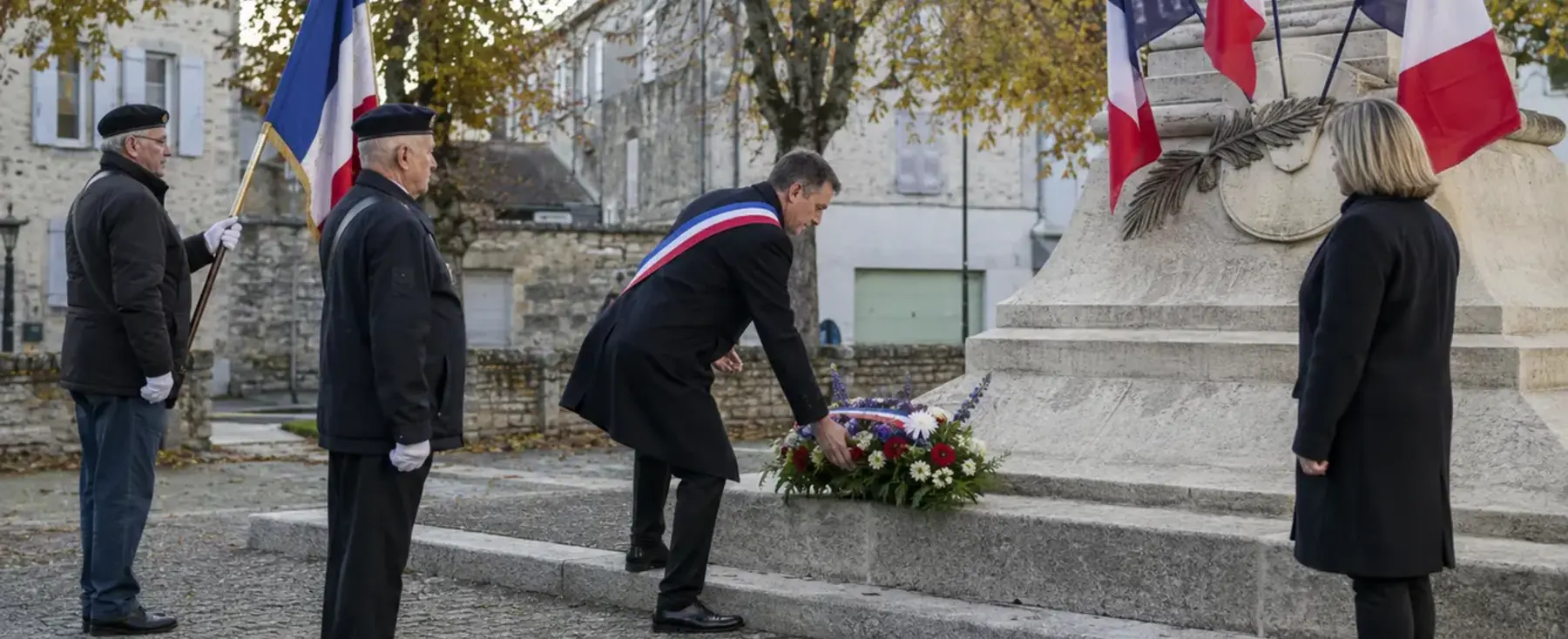 Dépôt de gerbe devant un monument aux morts dans une commune française