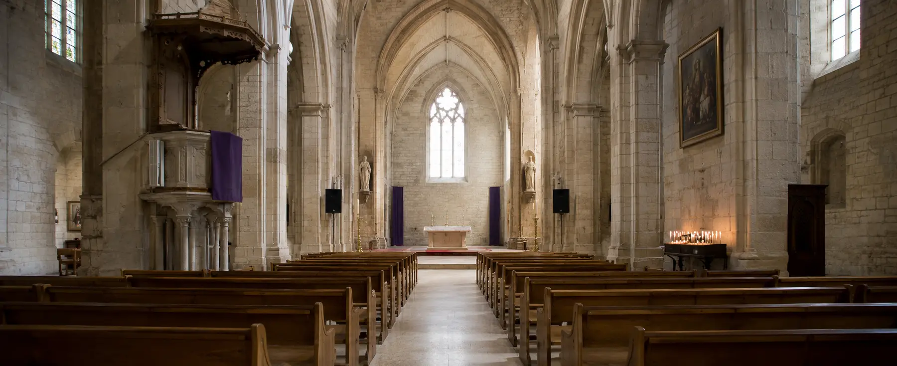 Nef d’une église sobrement éclairée pendant une célébration de Carême