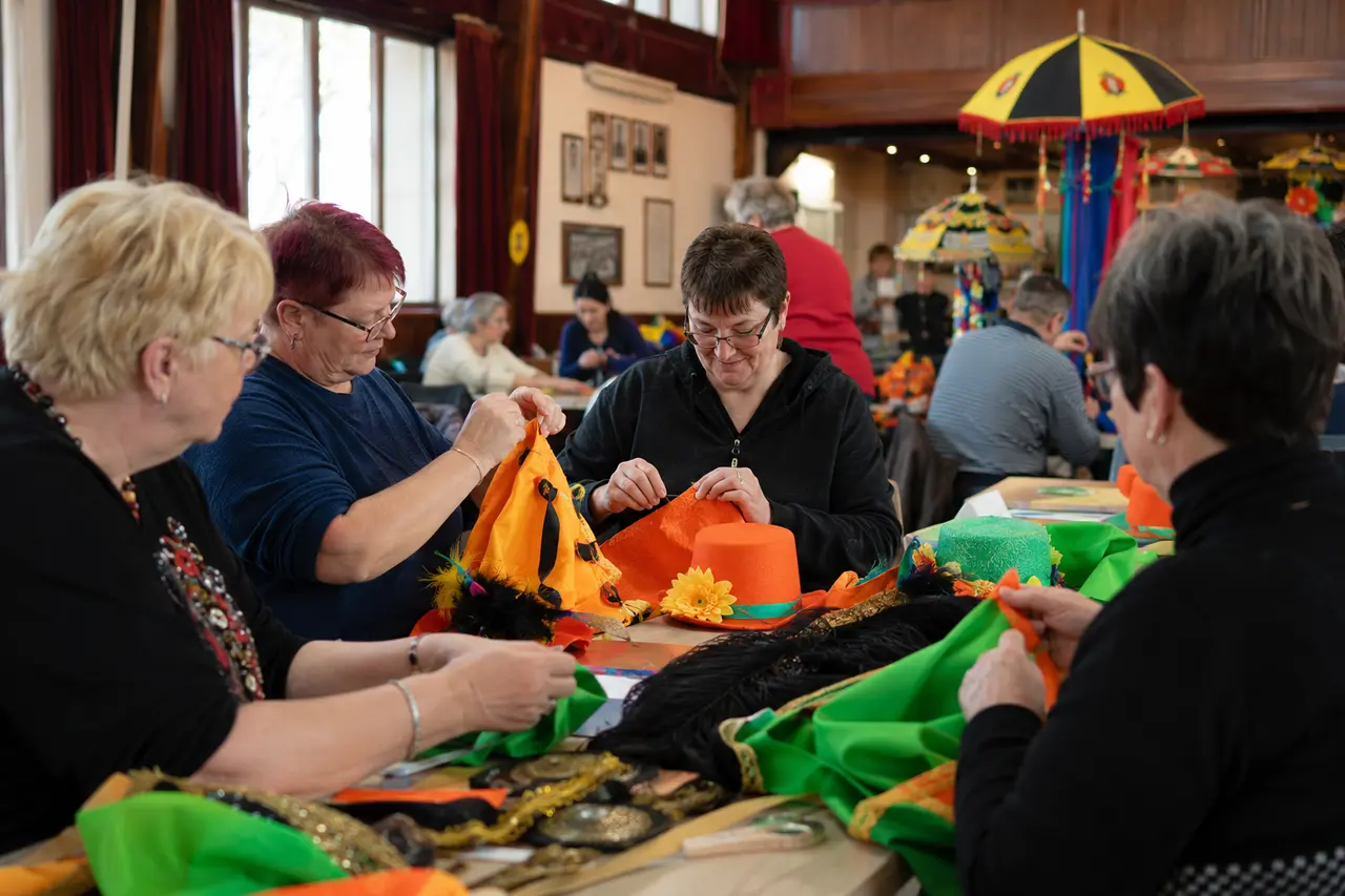 Adultes préparant ensemble des costumes colorés avant le Carnaval de Dunkerque