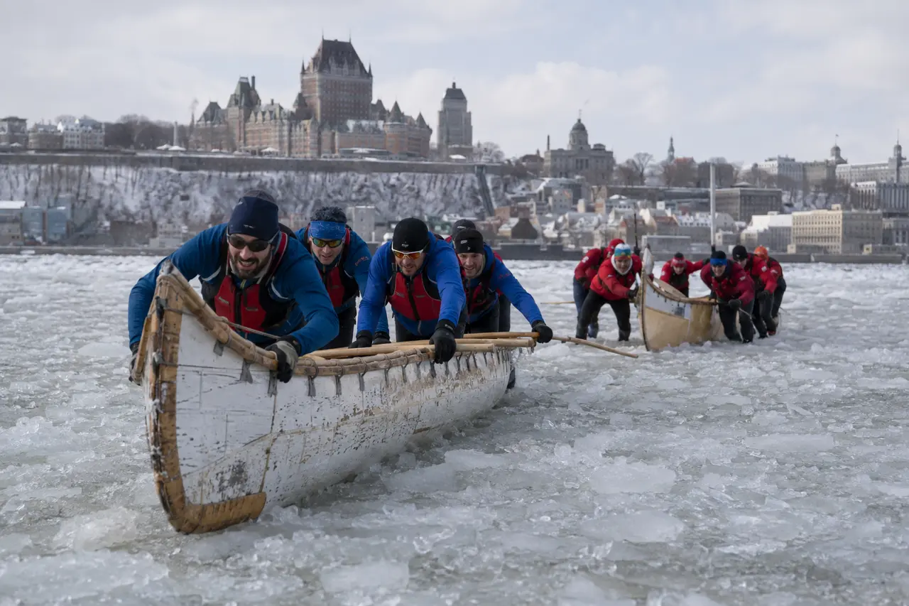 Équipes adultes avançant en canot sur les glaces du Saint-Laurent