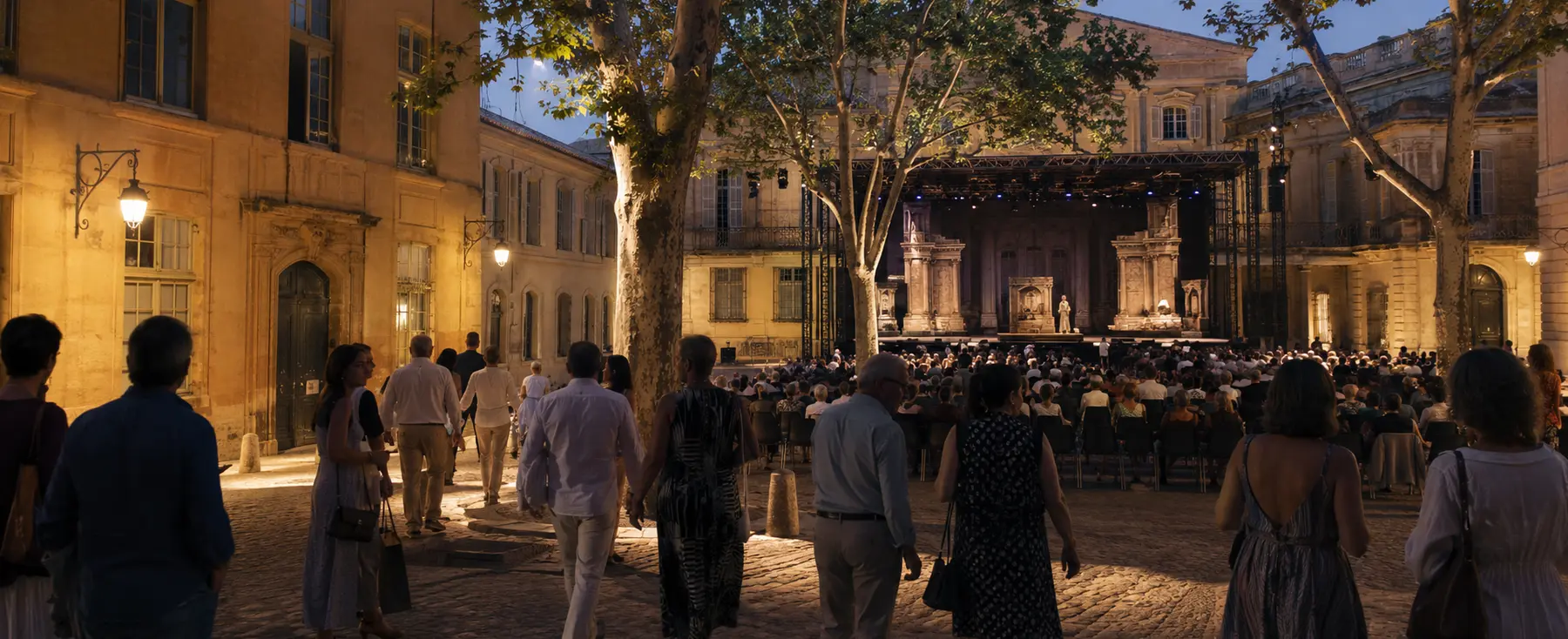Public arrivant dans une cour historique d’Aix avant une soirée lyrique