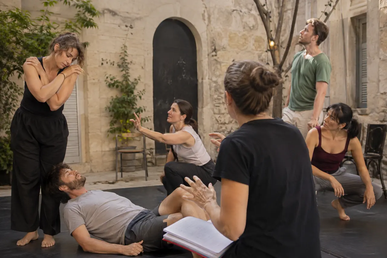 Compagnie adulte répétant un spectacle contemporain dans une cour d’Avignon