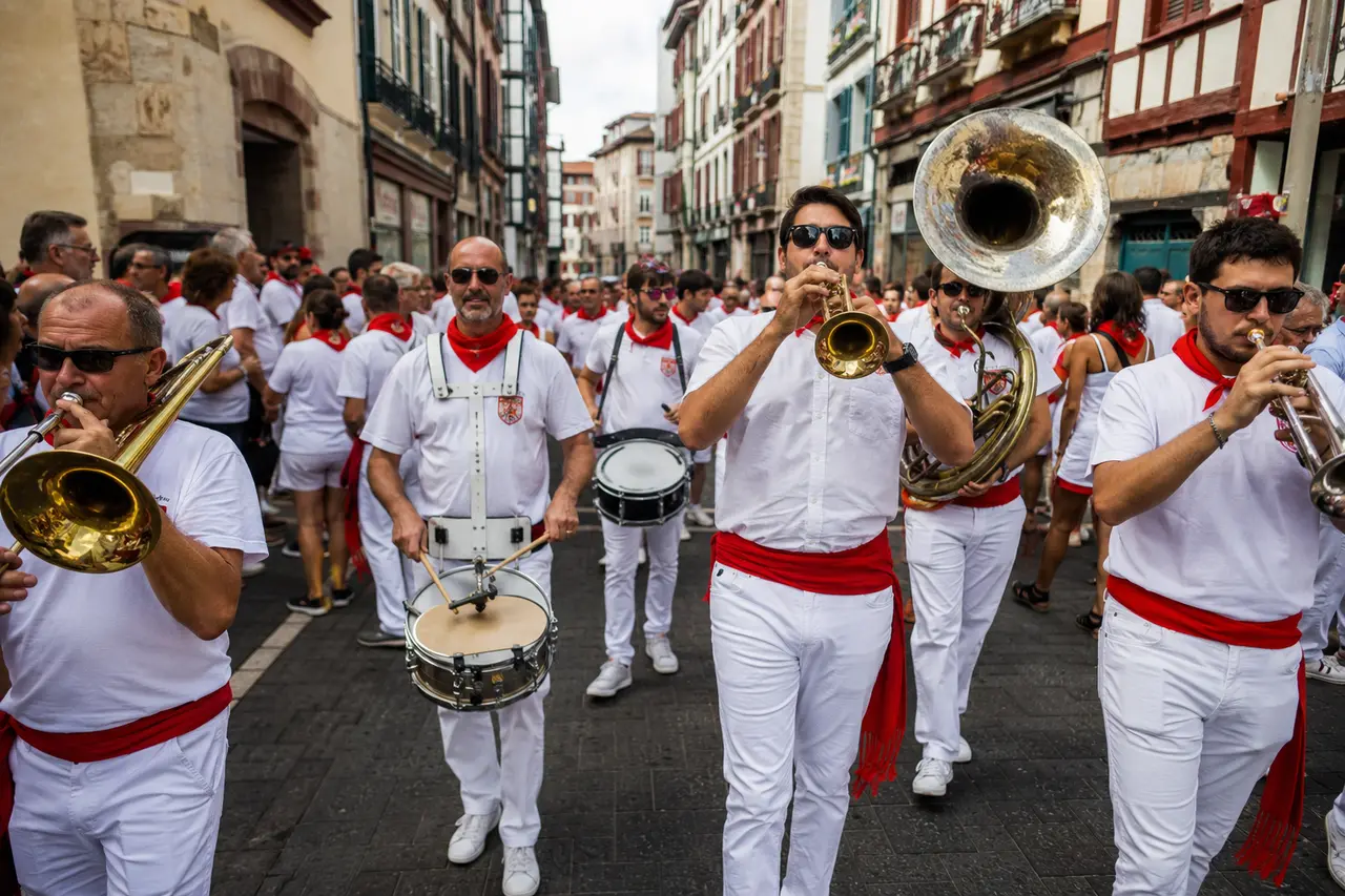 Banda adulte en blanc et rouge jouant dans une rue de Bayonne