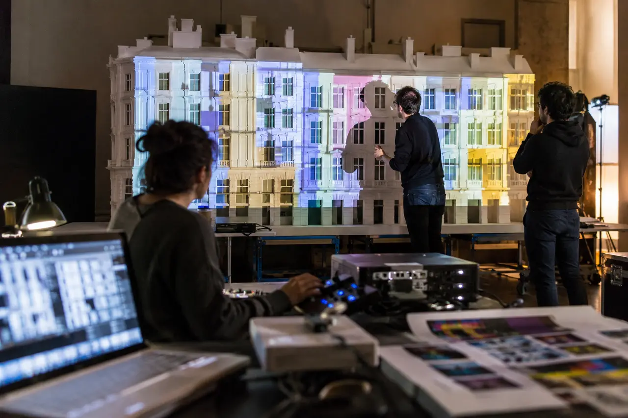 Artistes et techniciens réglant une projection architecturale avant la Fête des Lumières