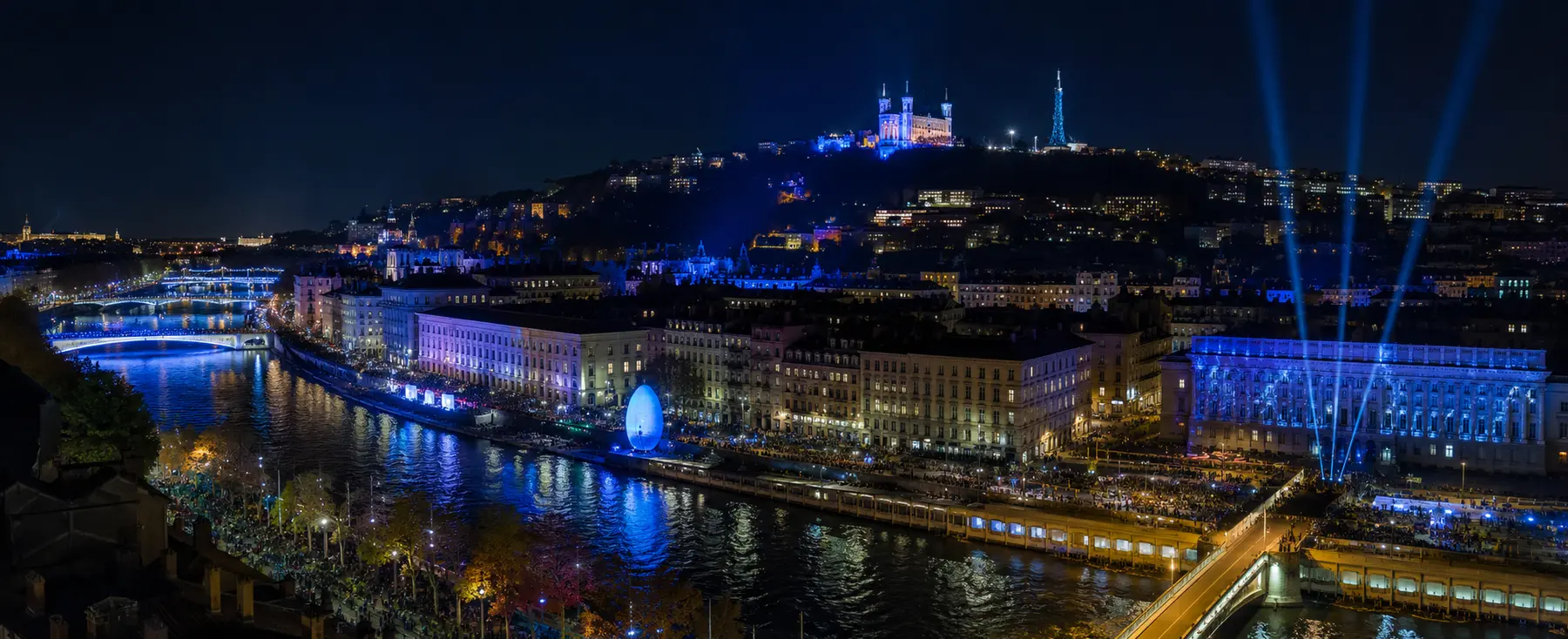 Panorama nocturne de Lyon avec installations lumineuses le long de la Saône
