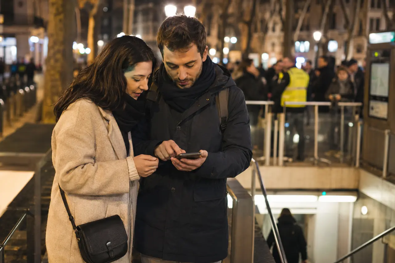 Deux visiteurs adultes consultant le parcours près d’une station de métro lyonnaise