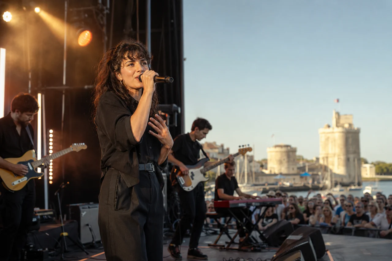 Chanteuse francophone fictive et musiciens sur une scène estivale à La Rochelle