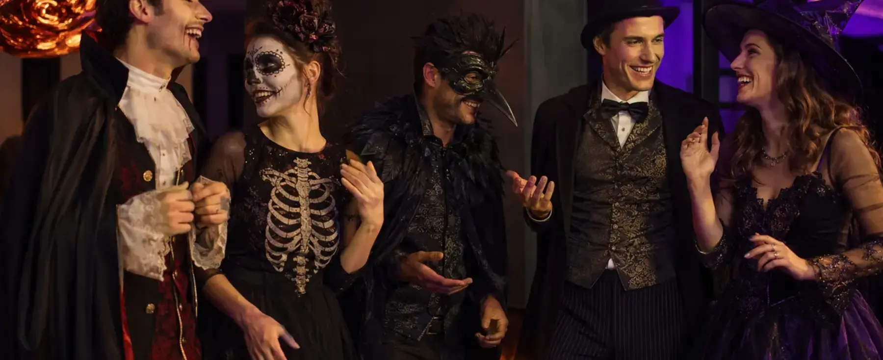 Cinq adultes aux costumes variés pendant une fête d’Halloween