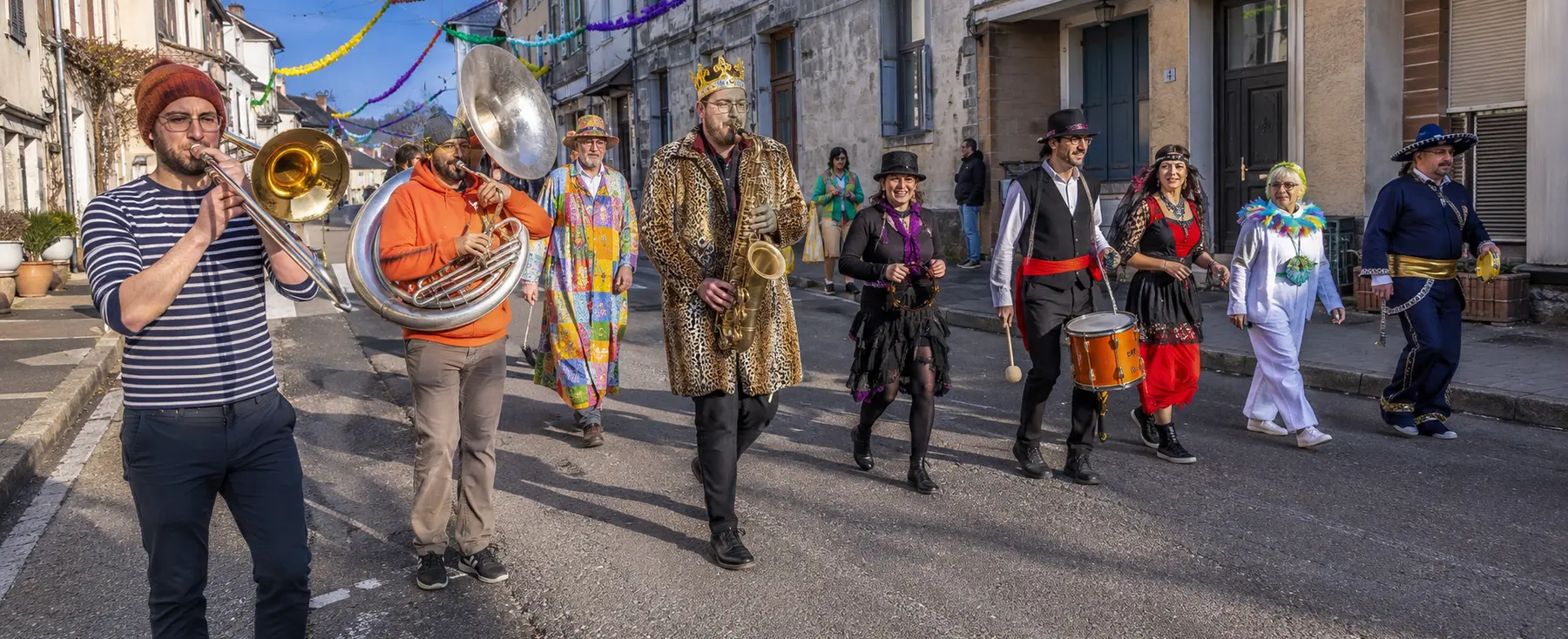 Petit défilé de Mardi gras avec fanfare et familles dans une rue française