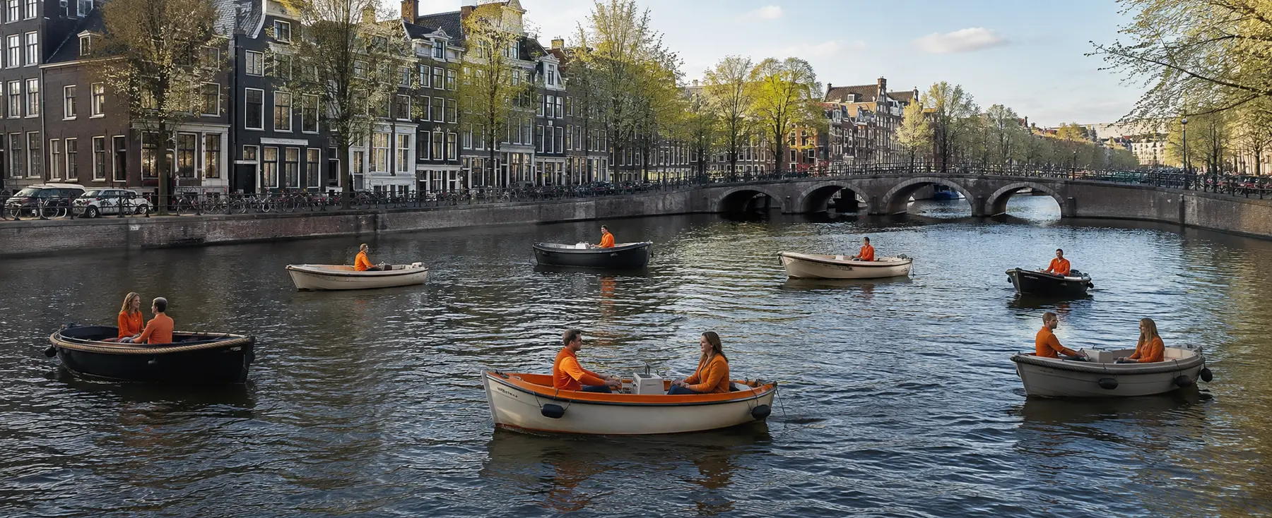 Petits bateaux avec passagers vêtus d’orange sur un canal d’Amsterdam