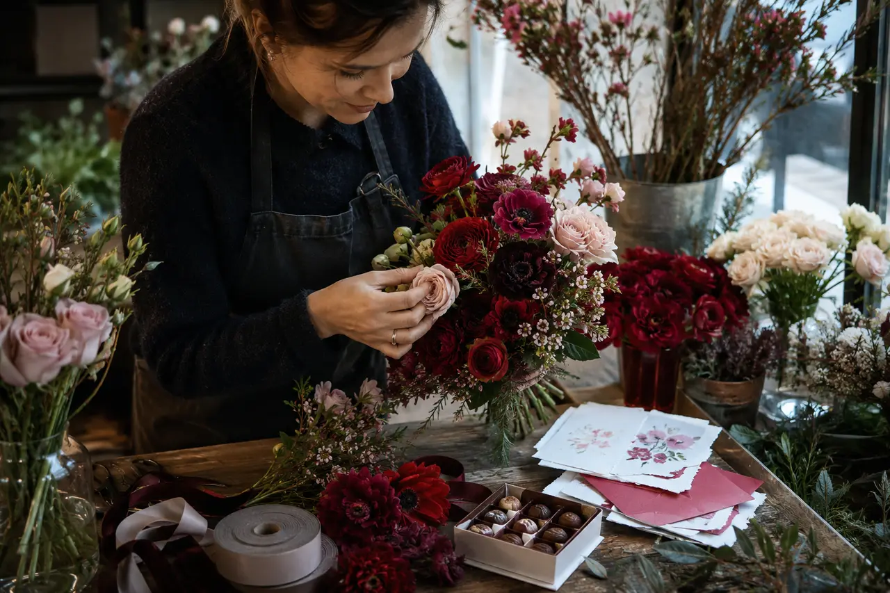 Fleuriste préparant un bouquet et des cartes pour la Saint-Valentin