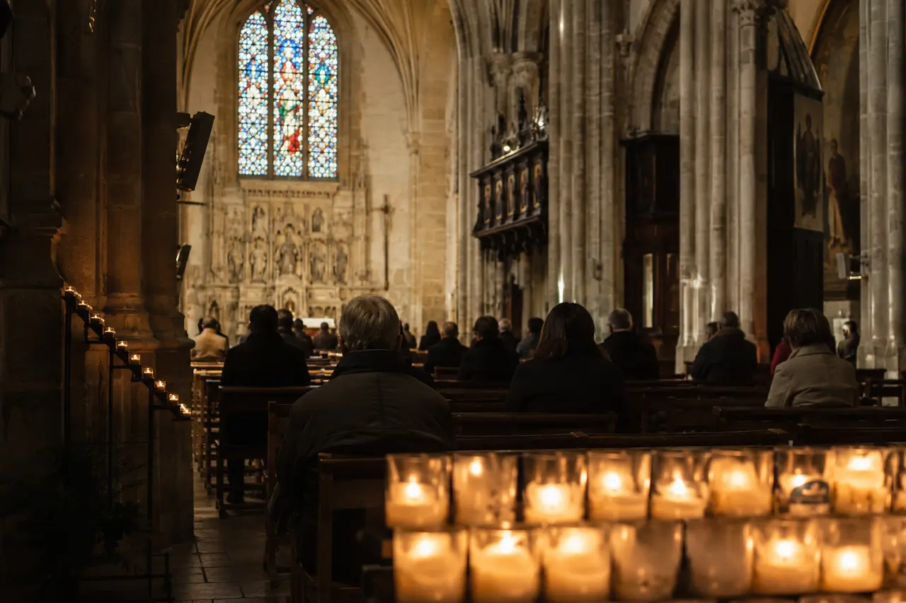 Fidèles et cierges dans une église française pour la Toussaint
