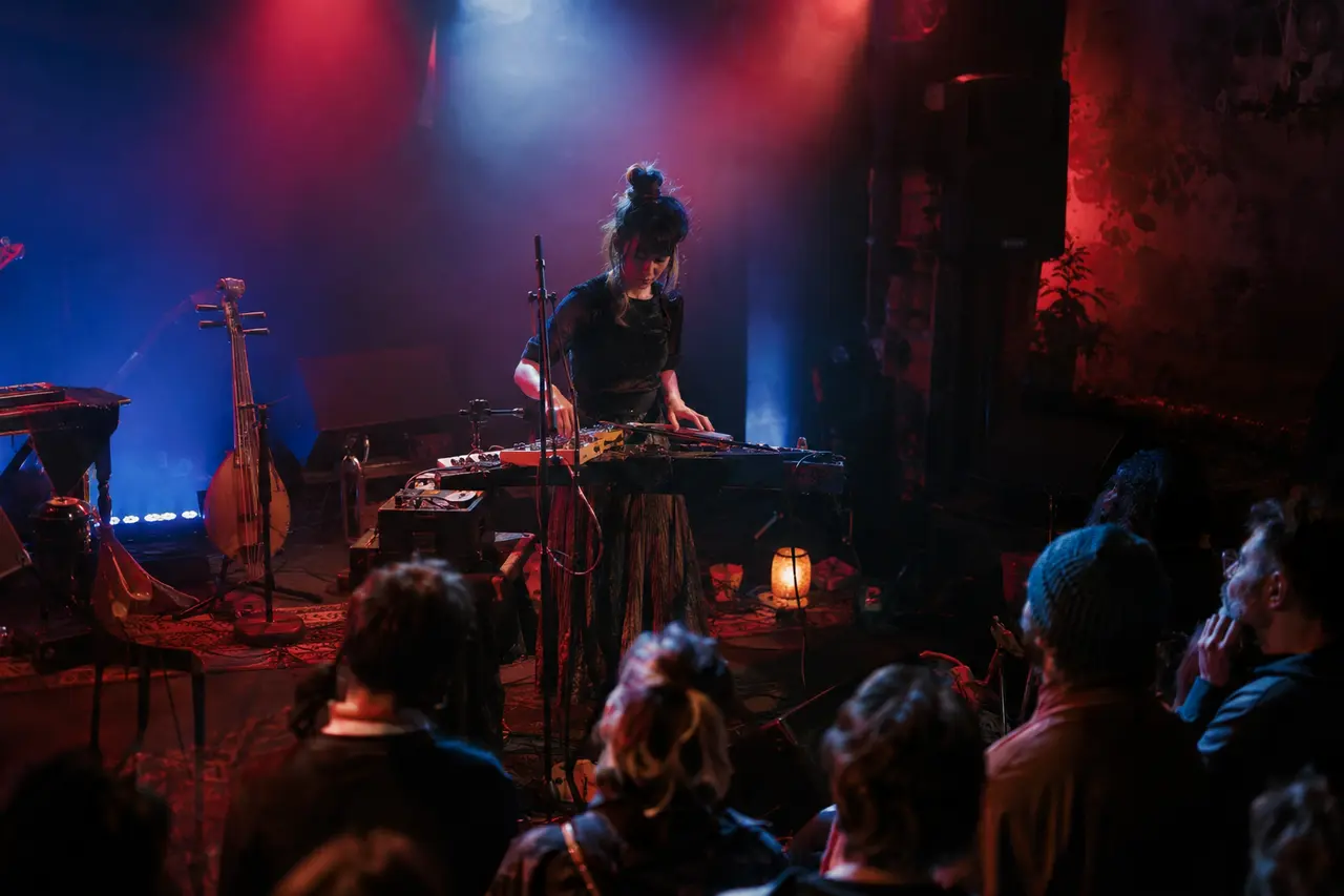 Artiste émergente présentant un concert expérimental sur une scène intime à Rennes